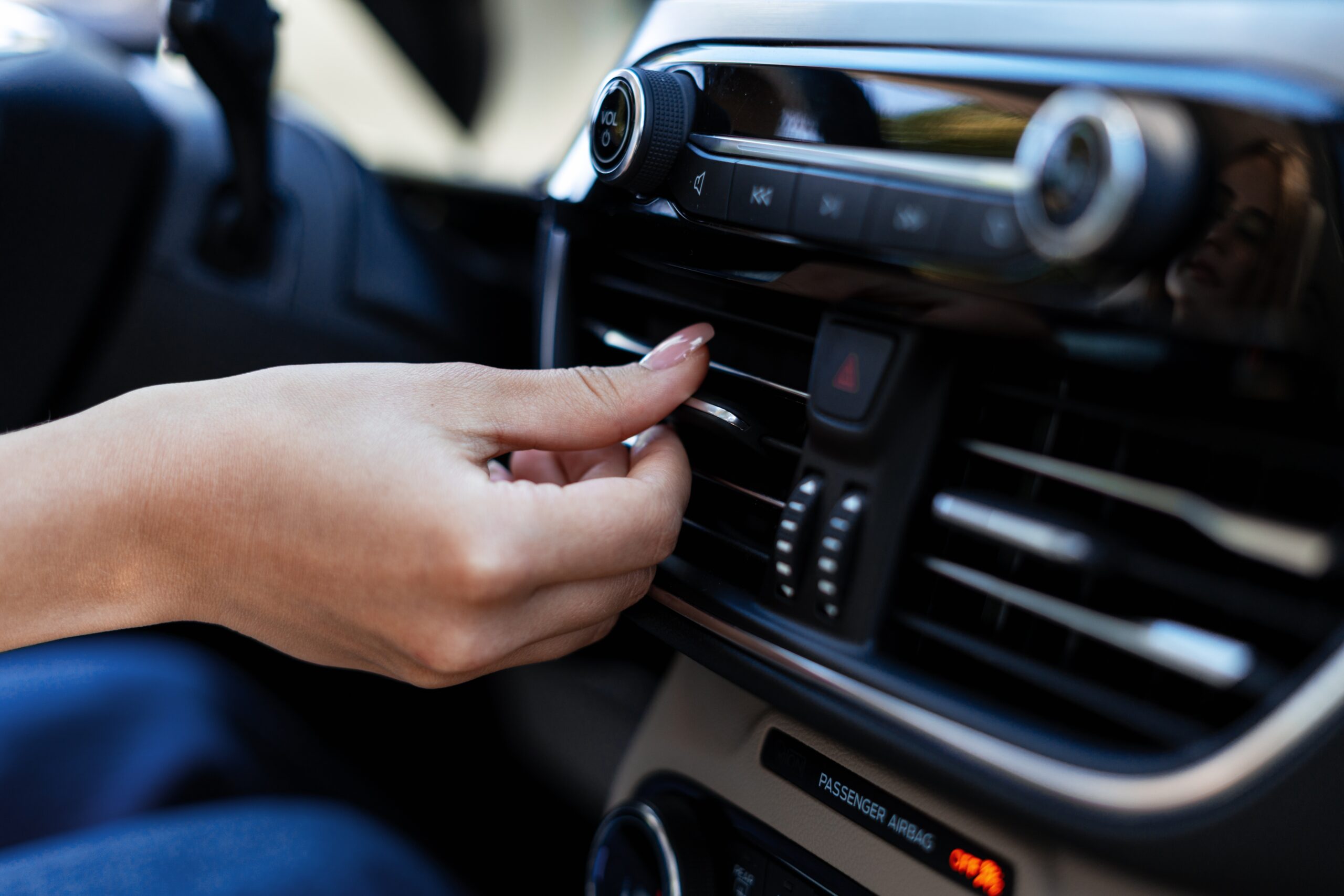 Female driver adjusting air conditioning controls