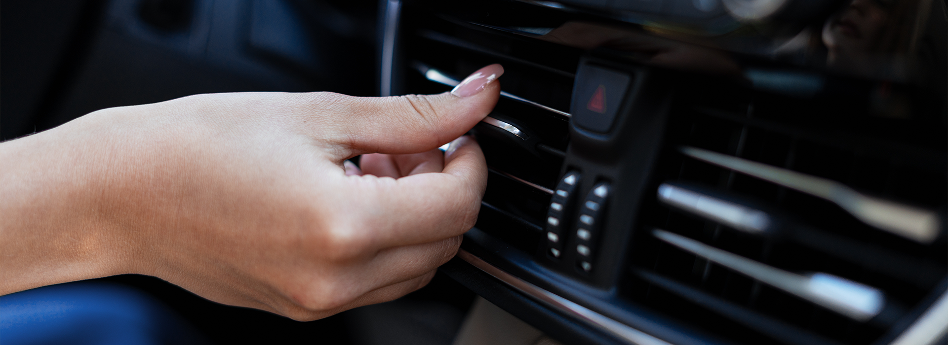 Female driver adjusting air conditioning controls
