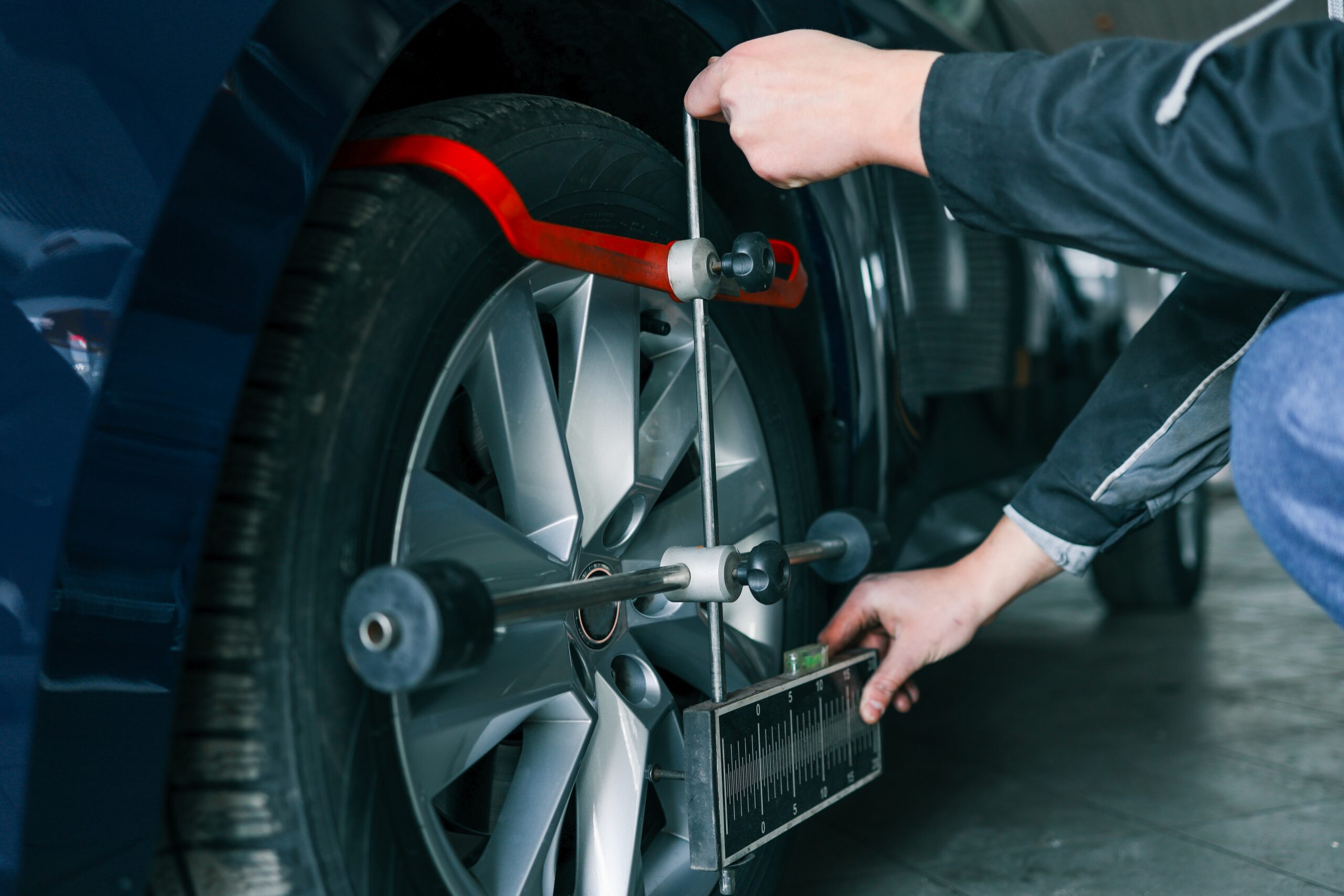 Auto mechanic adjusting a car's wheel alignment