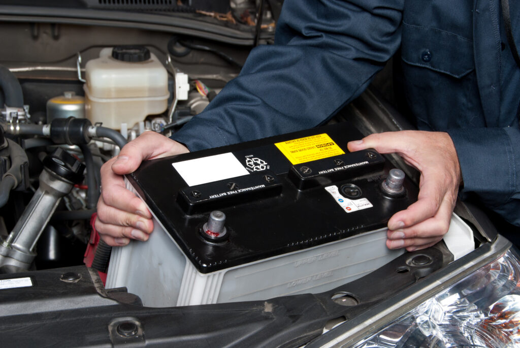 Auto mechanic replaces a battery