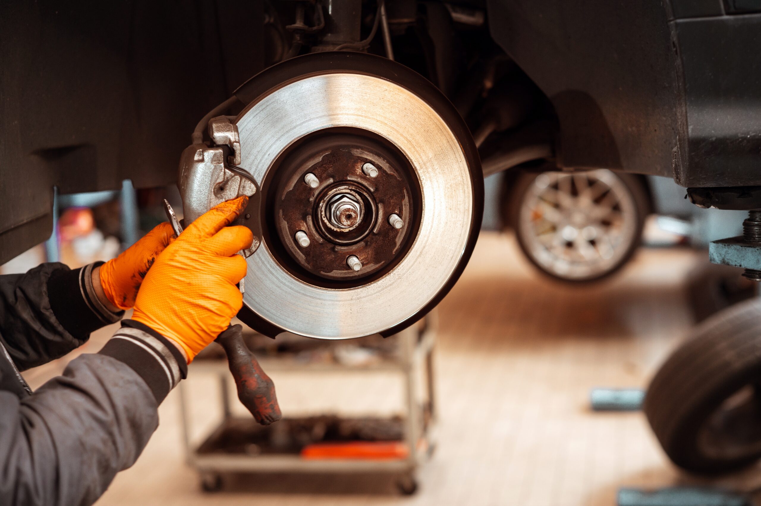 Auto mechanic replacing car wheel brake pad