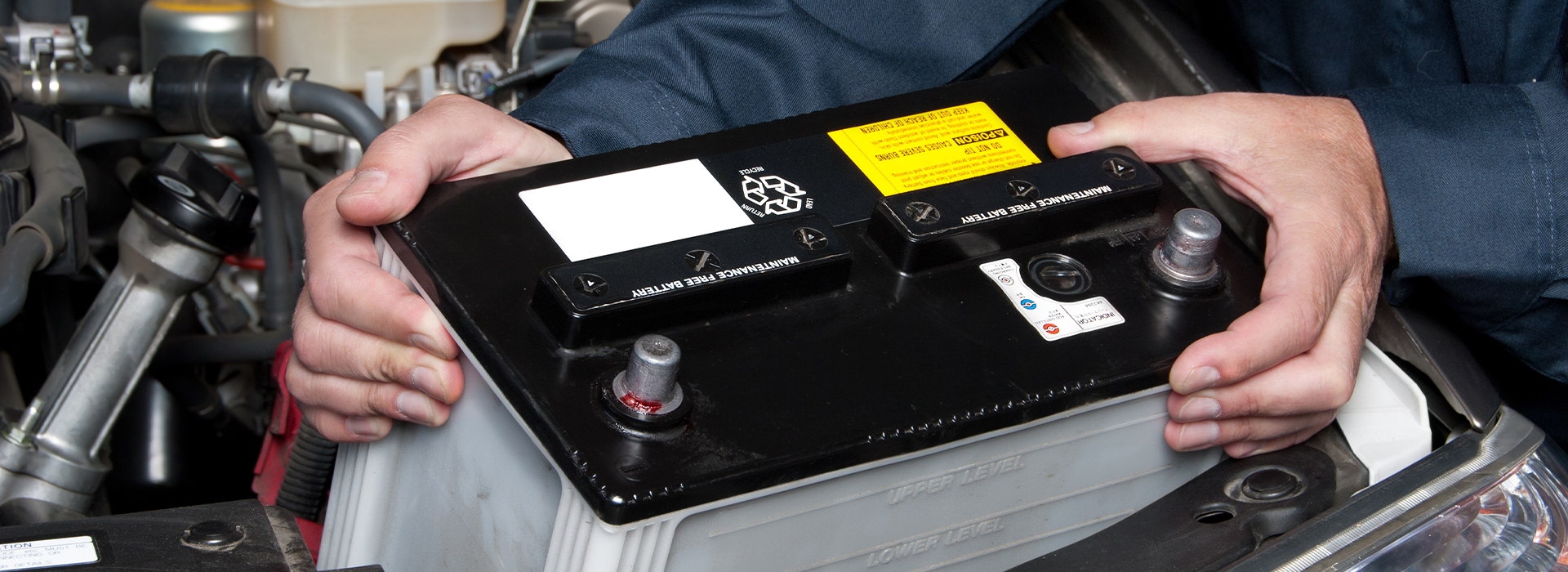 Auto mechanic replaces a battery