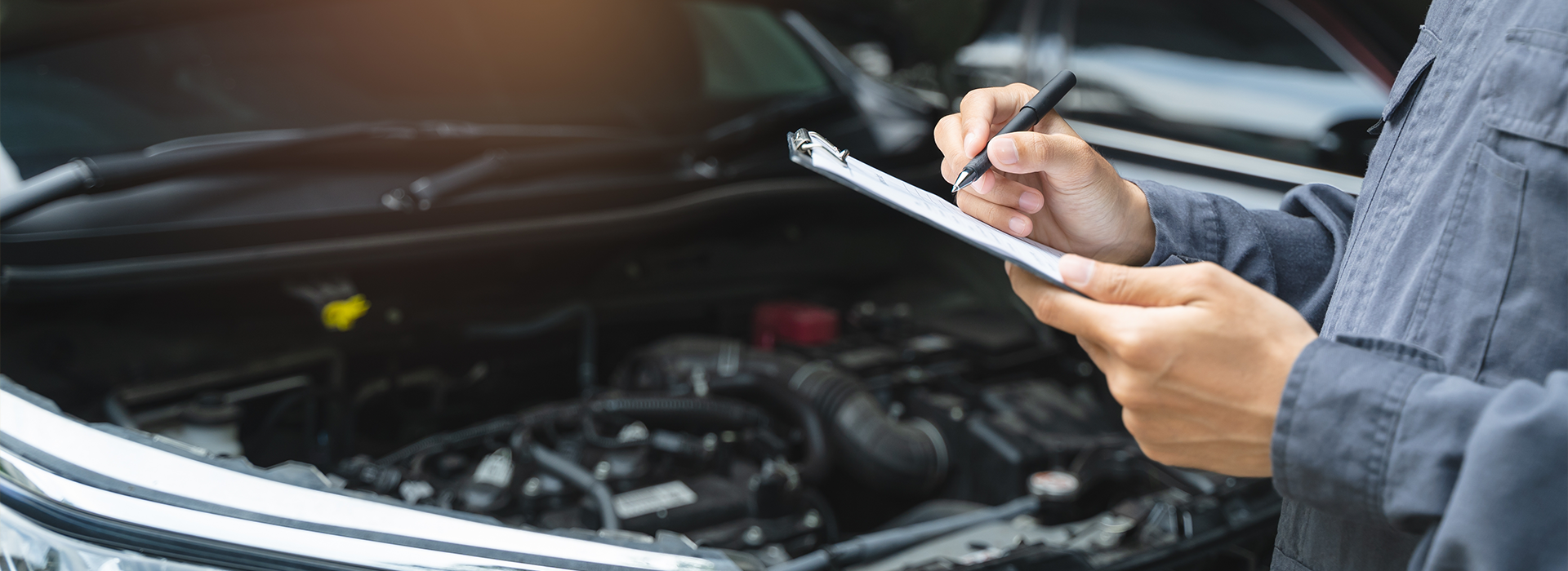 Auto mechanic writing checklist to estimate maintenance quote
