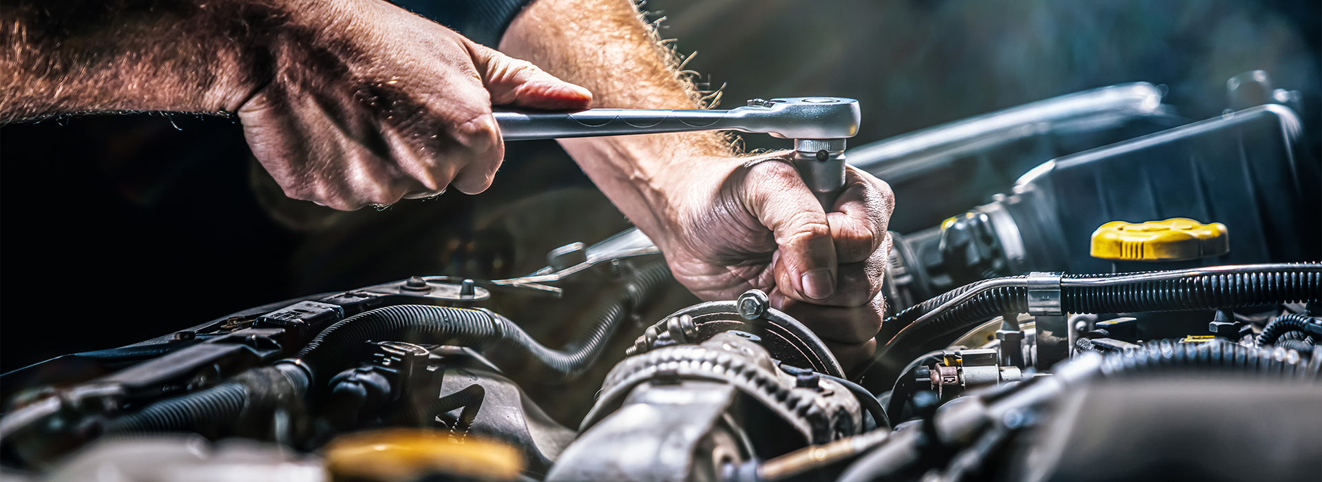 Auto mechanic working on car engine