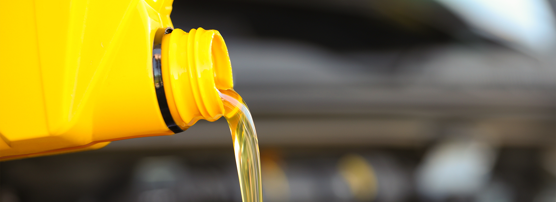 Pouring motor oil from yellow container