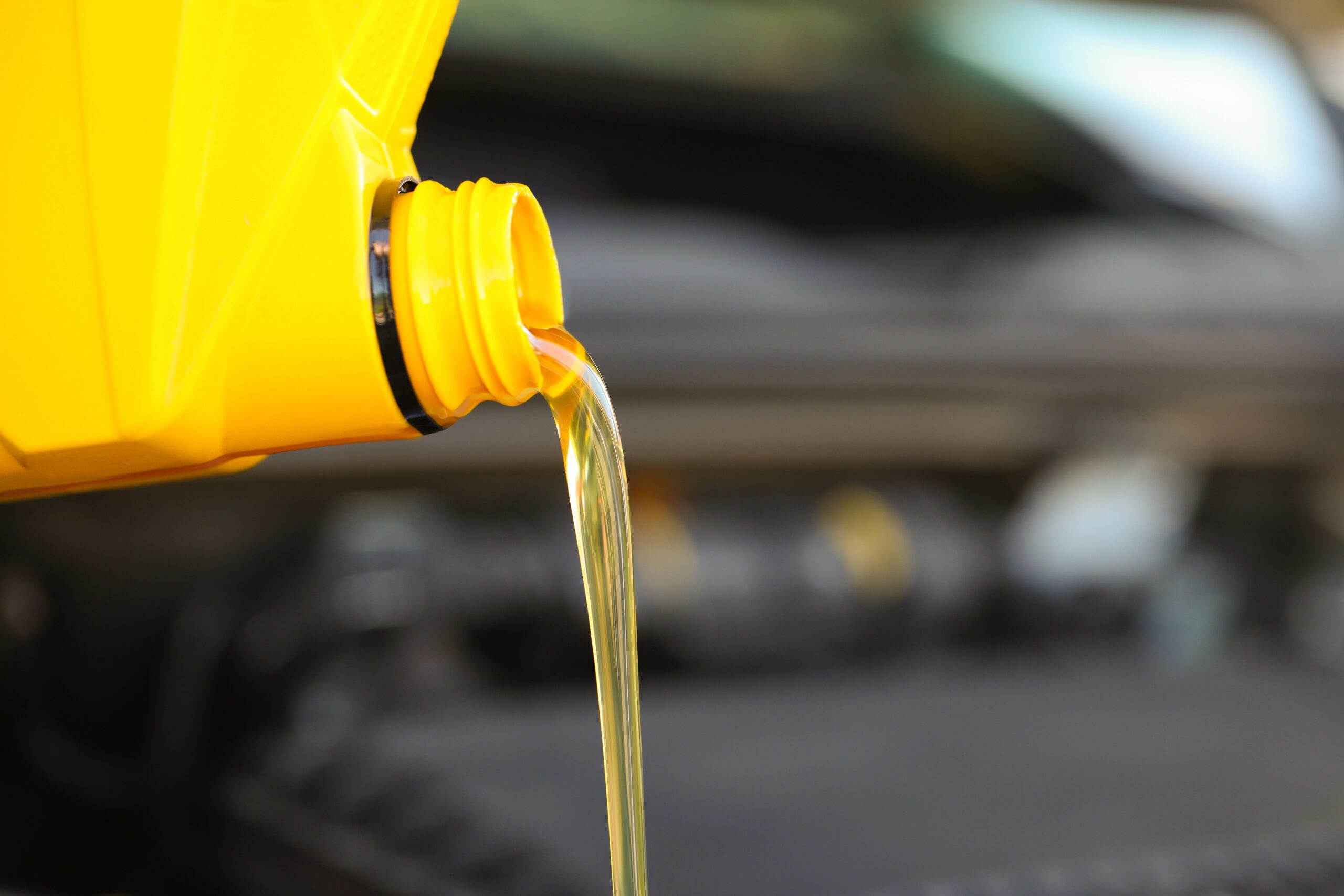 Pouring motor oil from yellow container