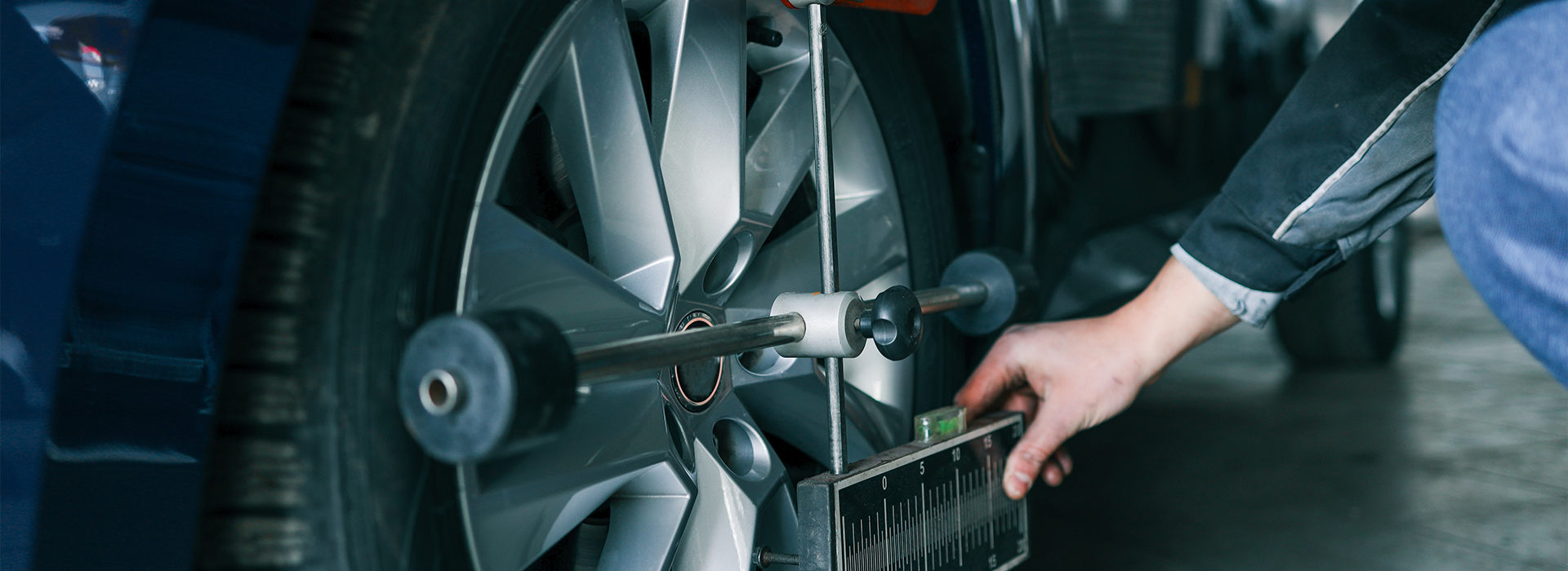 Auto mechanic adjusting a car's wheel alignment