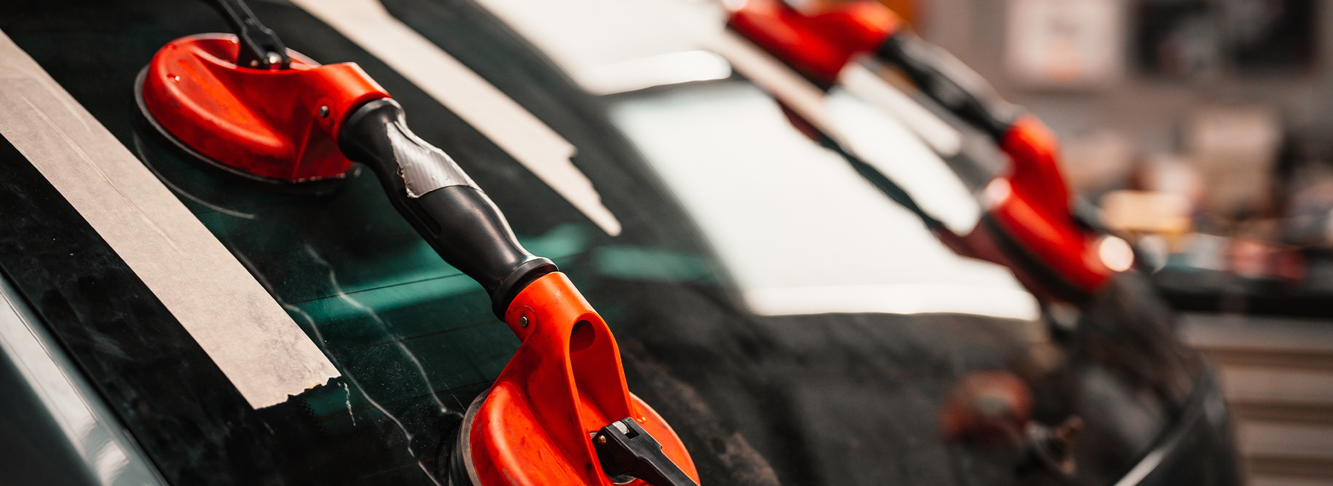 Auto mechanic replacing windshield