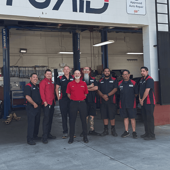 AutoAid team smiling in front of the AutoAid shop