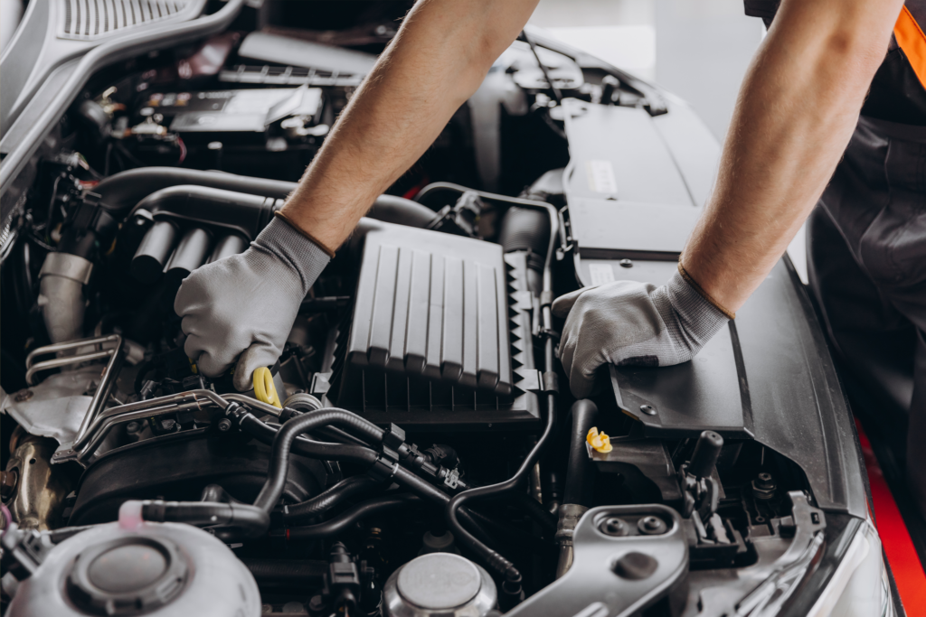 Auto mechanic inspecting a vehicle engine